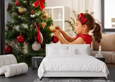 winter holidays and people concept - happy little girl decorating christmas tree at home Wall mural