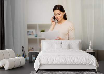 woman with papers calling on smartphone at home Wall mural