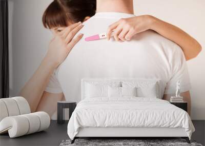 woman with pregnancy test hugging man Wall mural