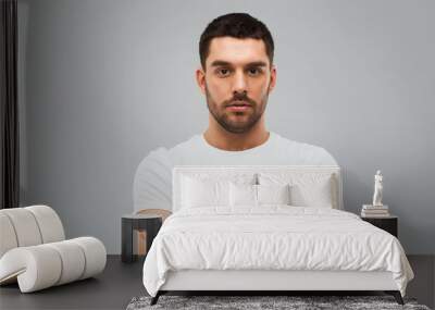 young man with crossed arms over gray background Wall mural