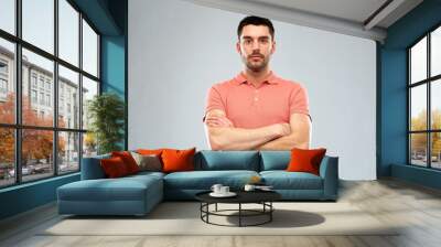 young man with crossed arms over gray background Wall mural