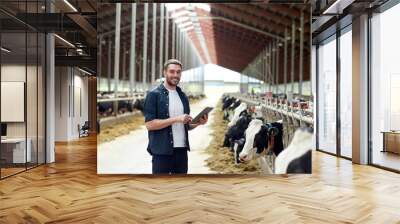 young man with tablet pc and cows on dairy farm Wall mural