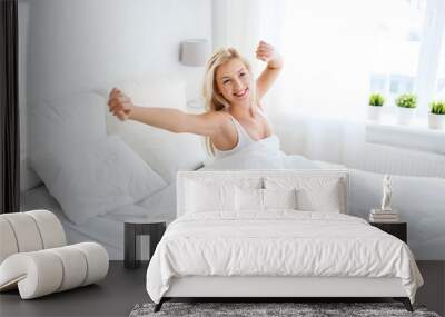 young woman stretching in bed at home bedroom Wall mural