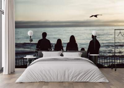 Family Feeding the Birds at Sunset Over Ocean Wall mural