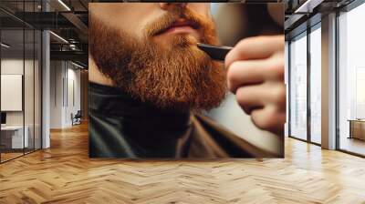 Barber expertly trims a stylish beard in a trendy barbershop, showcasing grooming skills with a hair clipper. Close-up image captures razor blade in action, perfect for beard styling Wall mural