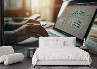 Businesswoman deeply analyzing financial charts on her laptop in the office, focusing on data with a pen in hand, showcasing dedication to finance and market trends Wall mural