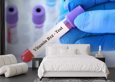 Doctor holding a test blood sample tube with Vitamin B12 test on the background of medical test tubes with analyzes Wall mural