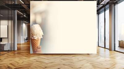 Happy little girl eating ice cream in a waffle cone against the backdrop of a sunny city street, cafe in summer.Banner. Copy space for text. Mockup Wall mural