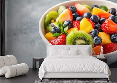 Vibrant fruit salad with strawberries, blueberries, mango, and kiwi on a dark background. Perfect for any time of day, packed with vitamins and antioxidants. Top-down view shows ripe, juicy fruits Wall mural