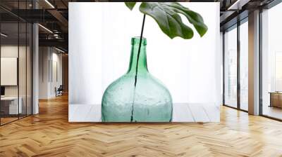 Demijohn vase with tropical leaf. Decoration glass vase. Interior photography and objects Wall mural