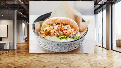 Bao with shrimp in paper in a plate. Rice buns with vegetable, seafood filling with sauce, sprinkled with sesame seeds. Fast food in a cafe, restaurant. Tasty dish Wall mural