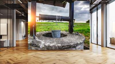 Ancient draw-well in European village Wall mural