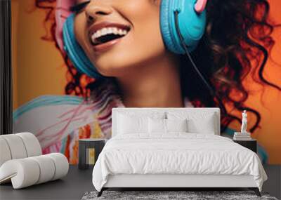 Beautiful smiling woman in headphones listening music on orange Wall mural