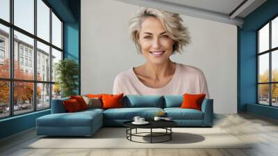 Mid aged adult confident smiling European woman with blonde short hair, happy healthy attractive 40 years old mature lady blond model looking at camera on pastel background, close up face portrait. Wall mural