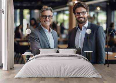 Portrait of two businessmen shaking hands while standing in a coffee shop. Wall mural