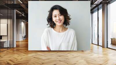 Portrait of young asian woman smiling and looking at camera. Wall mural