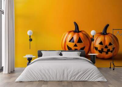 Two pumpkins with smiling faces are on a yellow background Wall mural