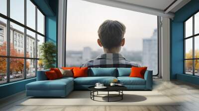 Back view of teen boy looking through window, sad orphan kid waiting on adoption Wall mural