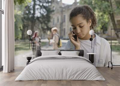 Upset schoolgirl calling parents, feeling lonely in school, suffering from bullying Wall mural