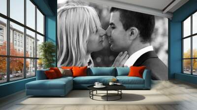 B&W beautiful elegant  blonde bride kissing handsome brunette groom close-up Wall mural