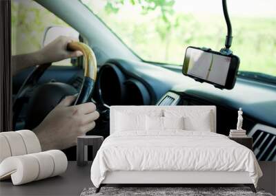 The driver uses a mobile smartphone with a GPS map navigation application. Wall mural