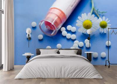 Chamomile flower and homeopathic medication on blue surface Wall mural