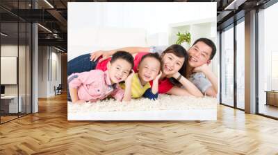 Asian family lying on the floor and smiling Wall mural