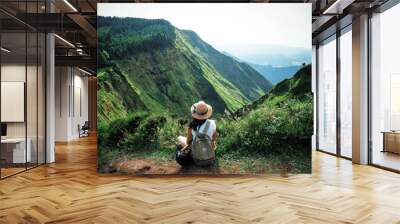 woman traveler holding hat and looking at amazing mountains and forest, wanderlust travel concept, s Wall mural