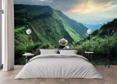 woman traveler holding hat and looking at amazing mountains and forest, wanderlust travel concept, space for text, atmospheric epic moment, azores ,portuhal, ponta delgada, sao miguel Wall mural