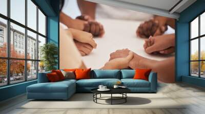 Holding hands, praying and people worship for peace, trust or faith in God at a table together. Pray, Christian and community by group hand in prayer, praise or blessing while united in Jesus Christ Wall mural