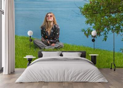 Energy healing and meditation concept, woman on a grass chilling and resting outside Wall mural