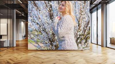 Romantic woman in knitted sweater and jeans at spring blossom garden. Concept of plus size woman and tenderness, modern beauty or femininity  Wall mural