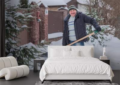 Snow collapse, man cleaning snow at winter weather with a shovel on a yard, winter trouble concept Wall mural