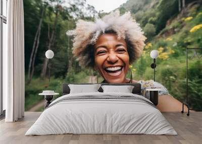 Smiling middle age black woman taking selfie while walking alone in mountains Wall mural