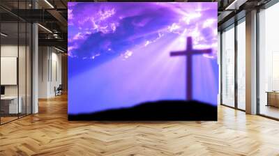 Cross on the Calvary hill with cloudy sky and sun light beams or rays. Abstract blury religious background. Wall mural