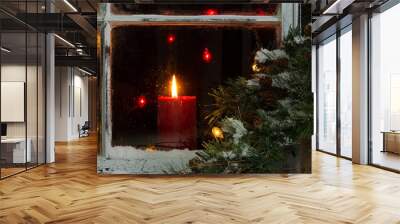 Glowing Christmas candle in frosted home window Wall mural