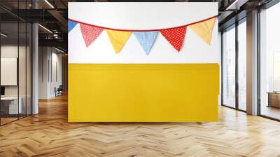 Hanging colorful bunting flags on white wall background. Yellow festive web banner. Festa Junina holiday, June Festival celebration concept. Decoration for birthday party. Decorative Midsummer frame. Wall mural