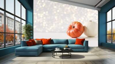 Modern autumn styled composition. White and orange pumkins on white table background. Halloween, Thanksgiving party concept. Festive fall design with golden sparkling bokeh lights. Empty space. Wall mural