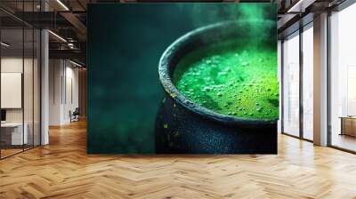 Steaming green potion in dark cauldron with bubbles. Wall mural