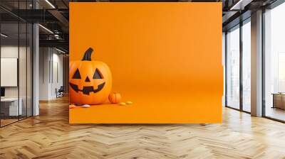 Halloween-themed image with a carved pumpkin and a bucket of candy on an orange background. Perfect for festive and holiday decorations. Wall mural