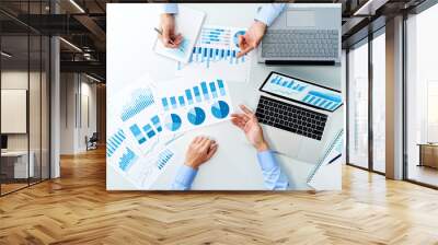 Top view of business meeting. Two men discussing. Many reports and laptops on white table. Wall mural