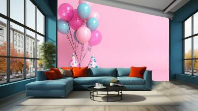 Baby pink background with playful balloons and a birthday hat, ready for a celebration. Wall mural