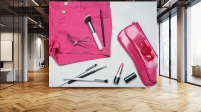 Assorted set of make up tools on pink jeans Wall mural