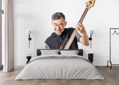 A funny Asian elder cool man has fashion in gray t-shirt And black vest play bass guitar. Shoot On white background in the studio. Positive active old cool senior healthy retirement concept Wall mural