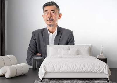 A senior Asian businessman in a classic gray suit shirt is happy, smiles, and proud. He has Crossed his arms with two hands. Studio shot over white background. Elderly, Positive and vision Concept Wall mural