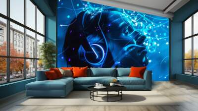 Young woman with headphones listening to music in neon blue light Wall mural