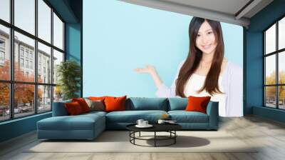 young asian woman showing on blue background Wall mural