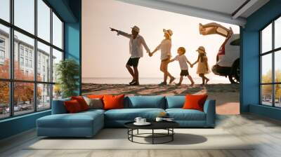 Asian family on the beach.Vacation time. Happy father, mother and son enjoying road trip the summer holidays.Parents and children are sitting on a hatchback with a sea background. Wall mural