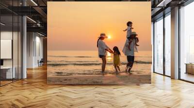 Happy asian family that enjoys beach activities during the summer holidays. parent and children enjoy the sunset sea on beach.Holiday travel concept, Summer vacations. Wall mural