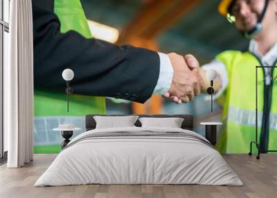 meeting, partner, plan, shake, renovation, agreement, deal, collaboration, foreman, handshake. Two men shake hands in a business meeting. One of them is wearing a green vest. Wall mural